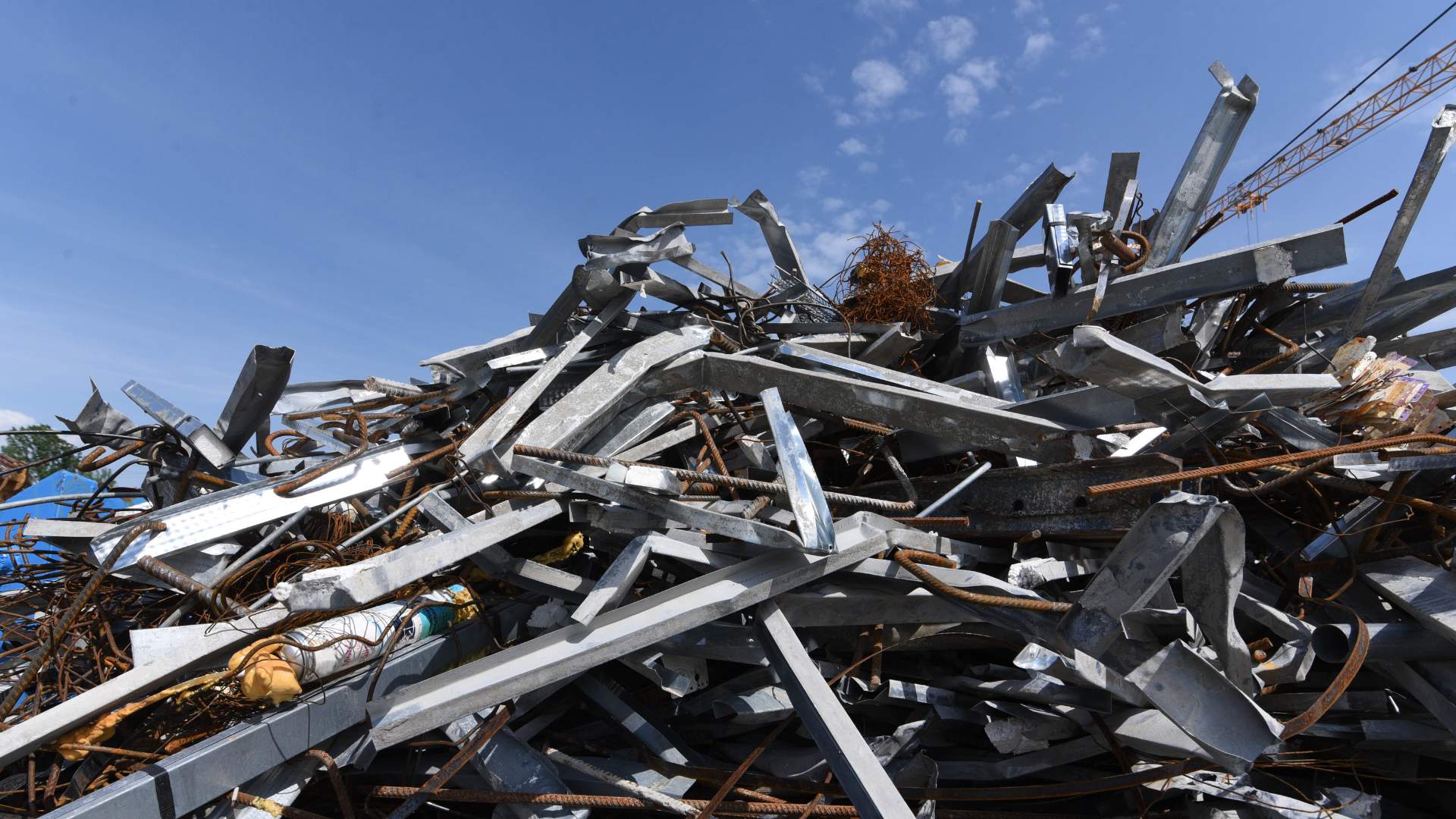 A pile of scrap metal below a blue sky.