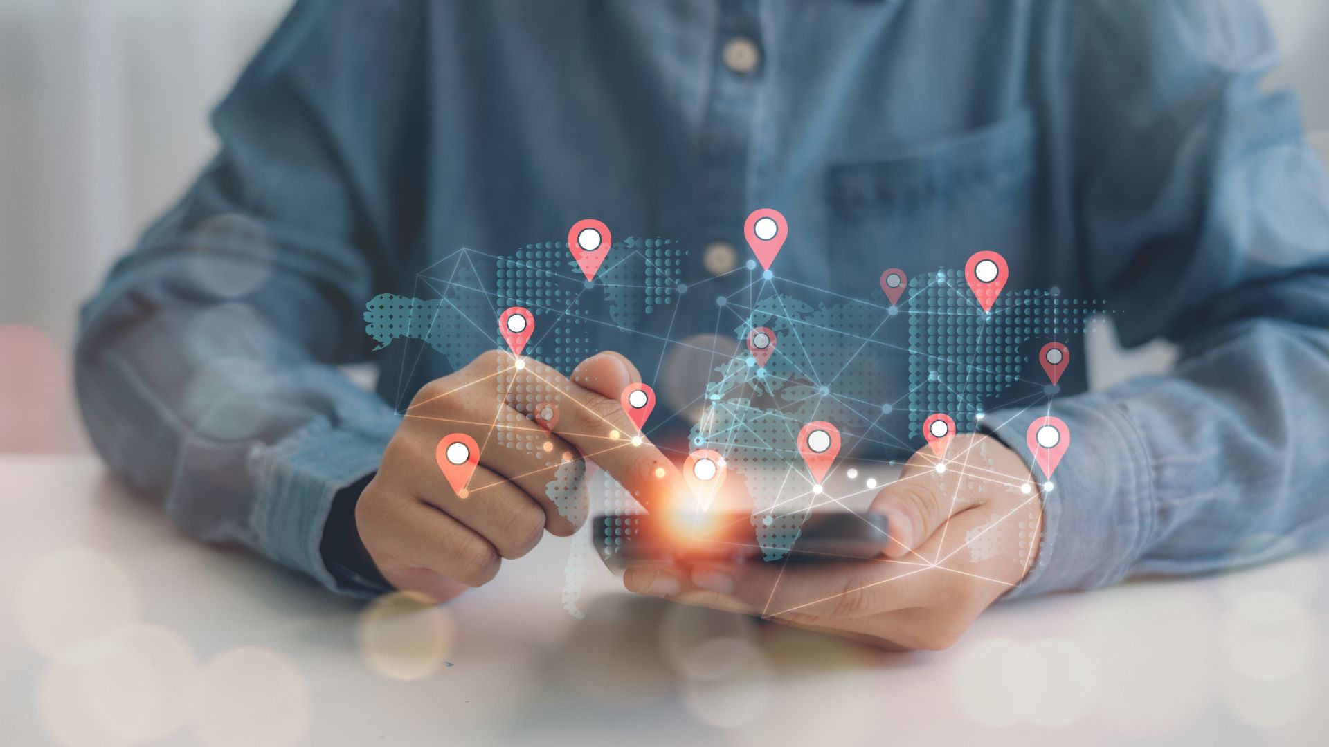 A person looking at a smartphone screen with location symbols surrounding the device.