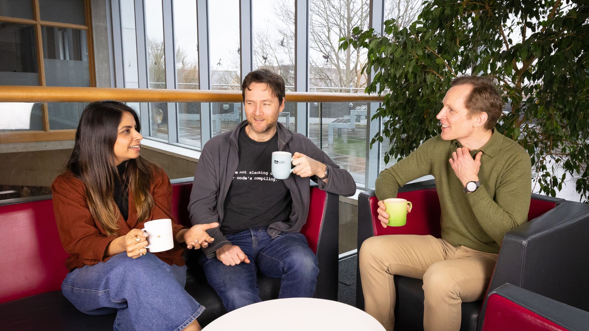 Three members of the Sensize team holding mugs and discussing tracking.