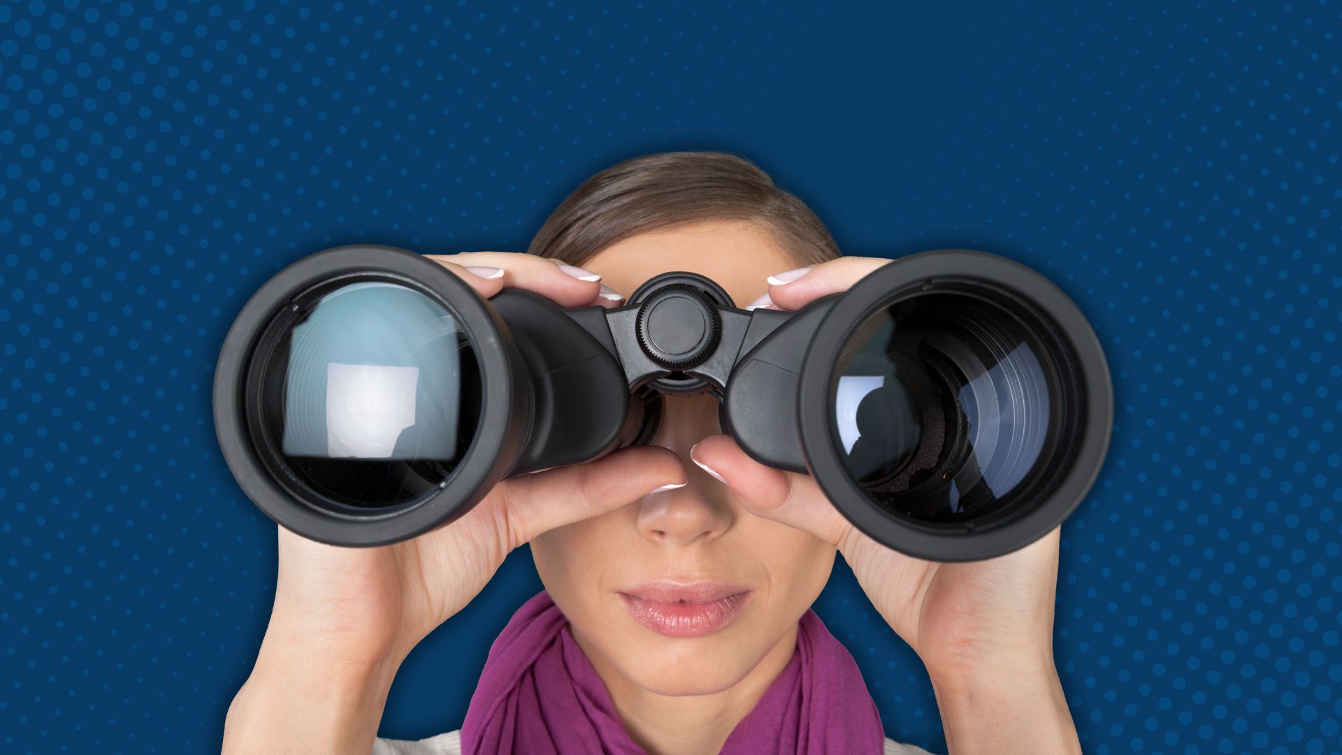Close-up of someone wearing pink looking through large binoculars. 